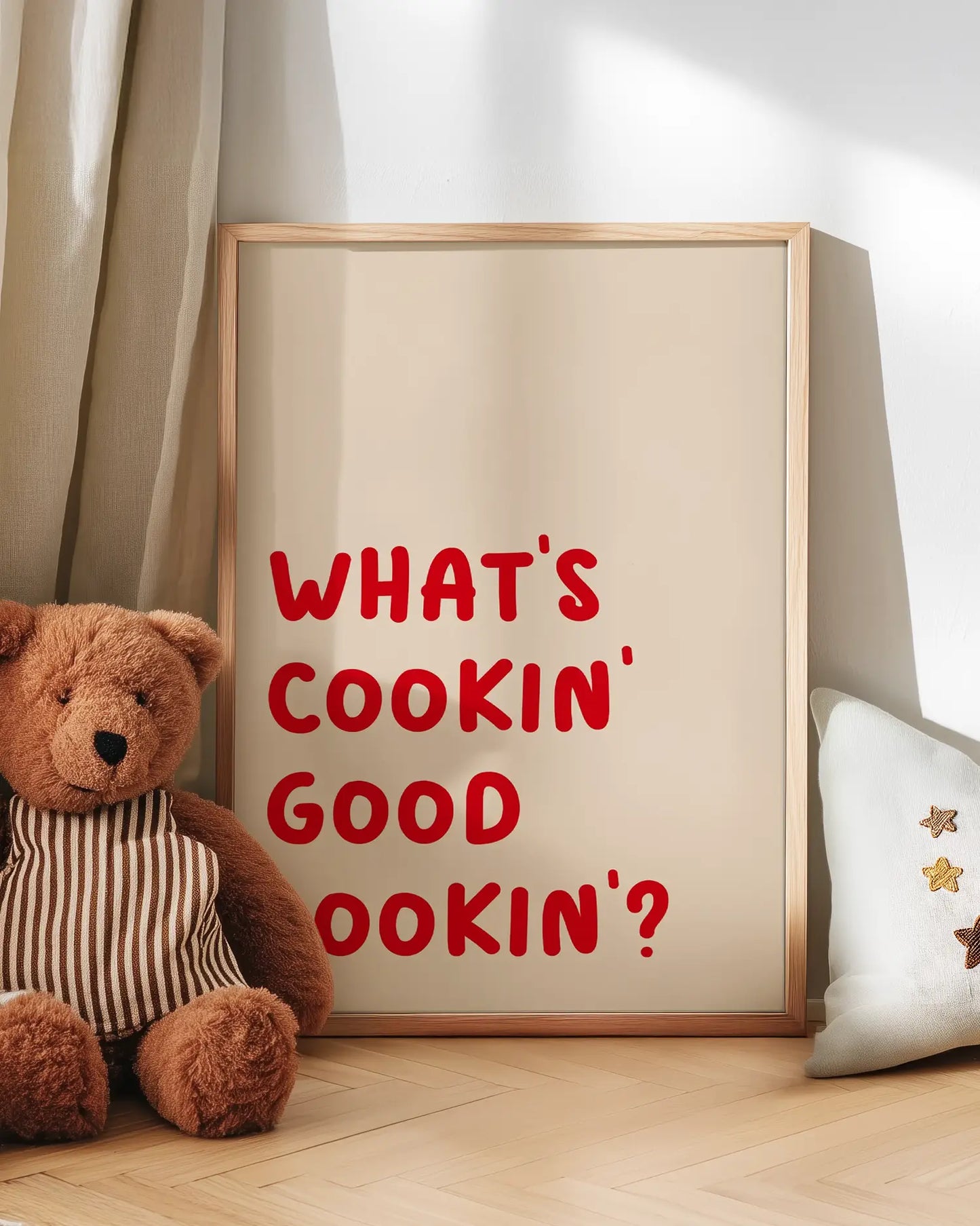 Barntavla med texten "WHAT’S COOKIN’ GOOD LOOKIN’?" i röd text, lutad mot vägg bredvid en mjuk nalle. En varm och charmig scen som passar perfekt i ett mysigt barnrum.