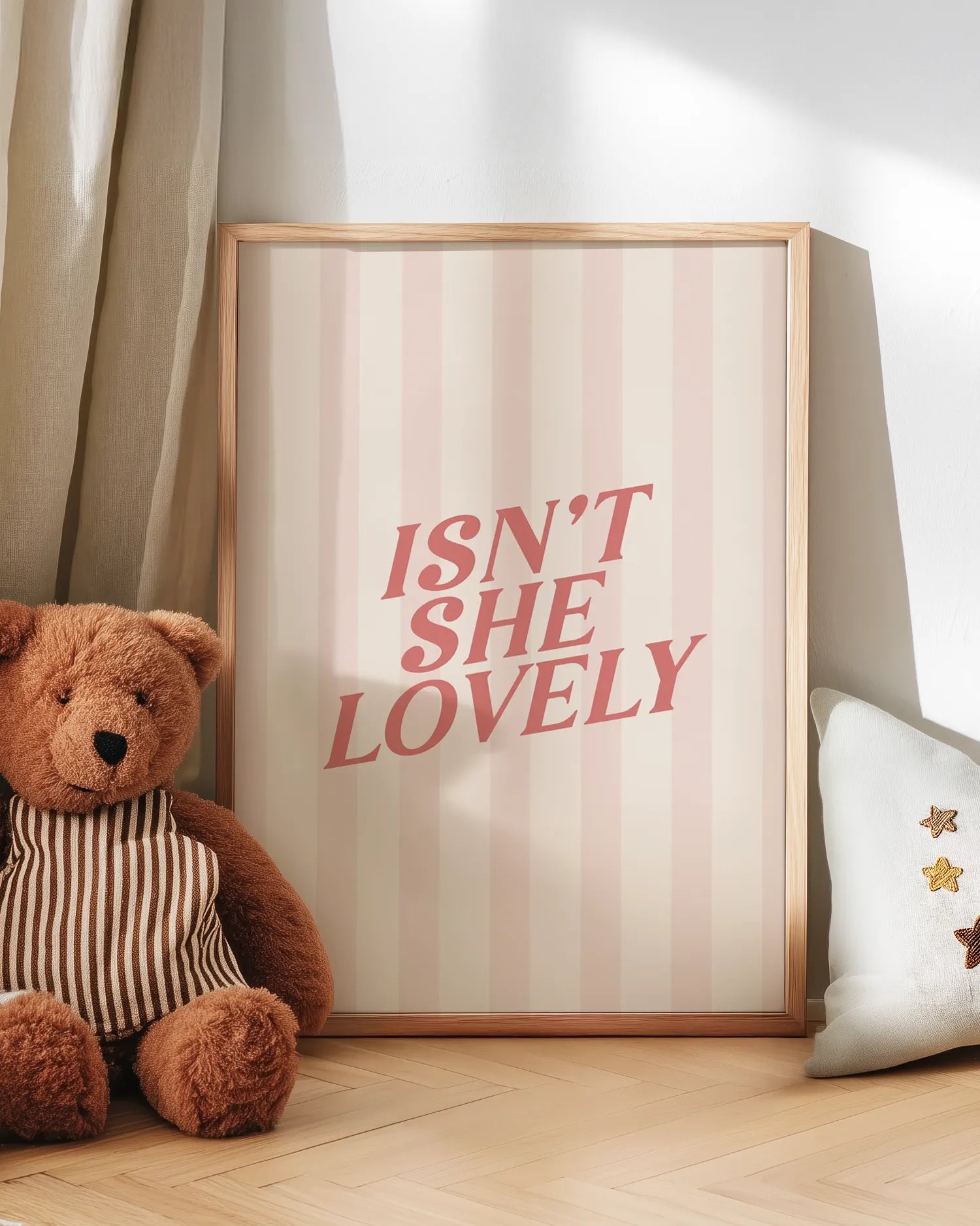 Inramad barntavla lutad mot väggen med en nalle intill, vilket skapar en mysig och trygg känsla i barnrummet.