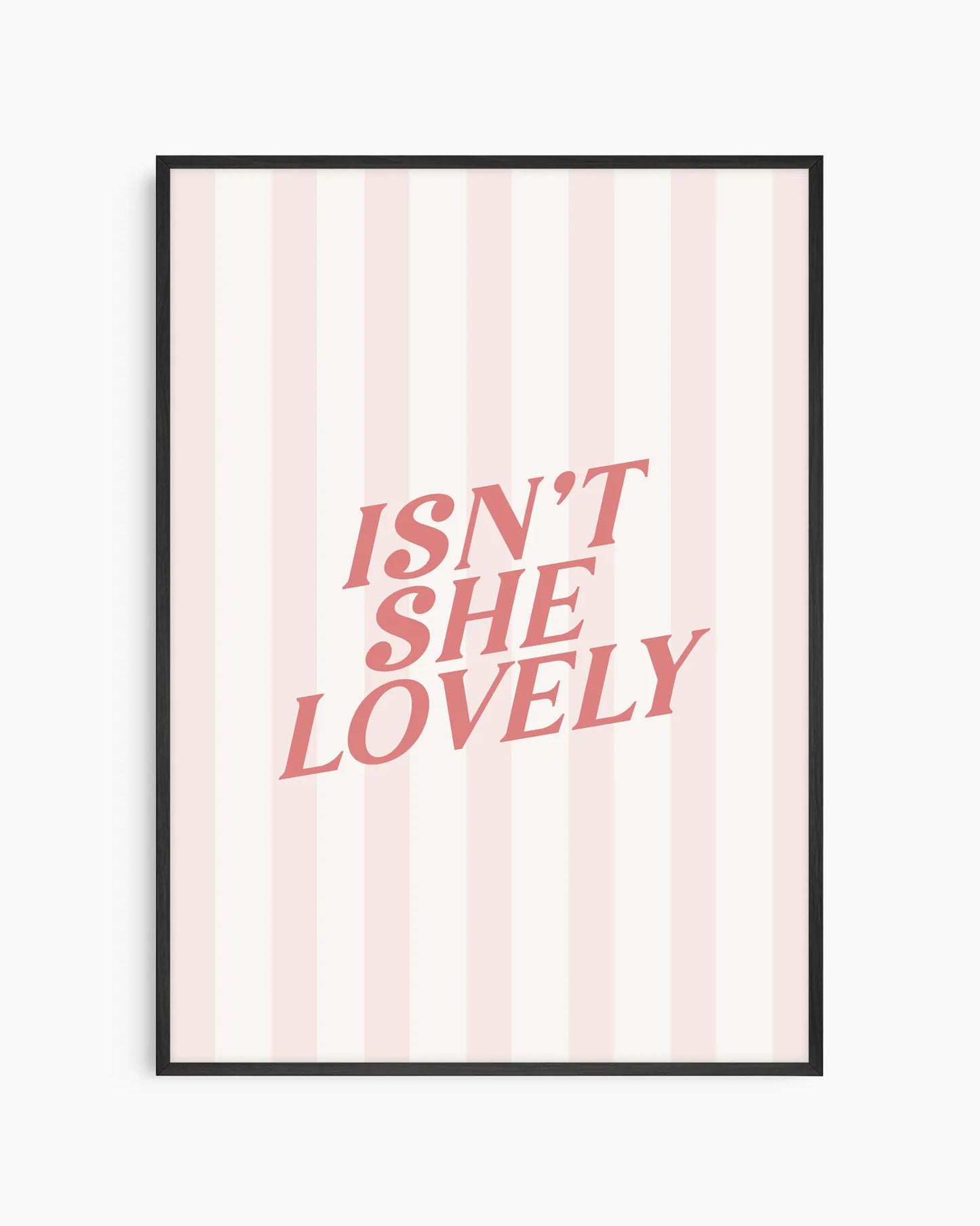 Barntavla med citatet "ISN'T SHE LOVELY" i mjuk rosa typografi mot ljus randig bakgrund. Den svarta träramen skapar en tydlig kontrast och ger ett modernt men varmt uttryck i barnrummet.