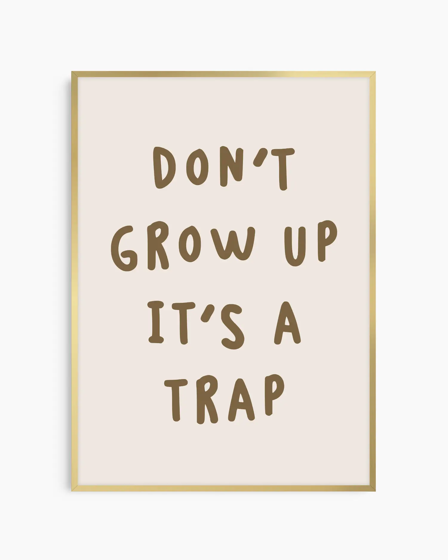 Barntavla med texten “DON’T GROW UP IT’S A TRAP” på beige bakgrund, inramad i guld aluminiumram som tillför en mjuk och elegant kontrast.