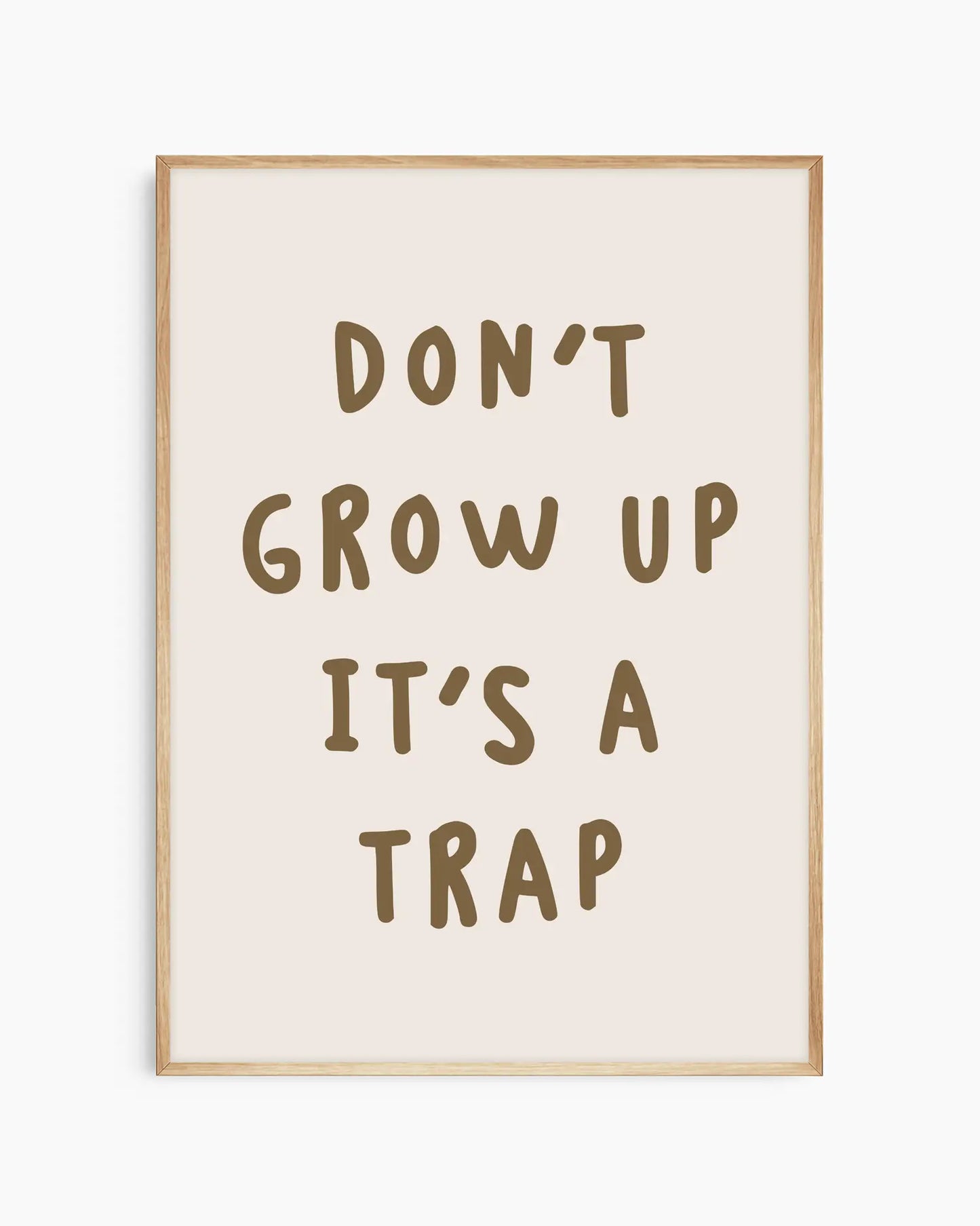 Barntavla med texten “DON’T GROW UP IT’S A TRAP” i brunt, inramad i ekram som ger ett naturligt och harmoniskt uttryck.