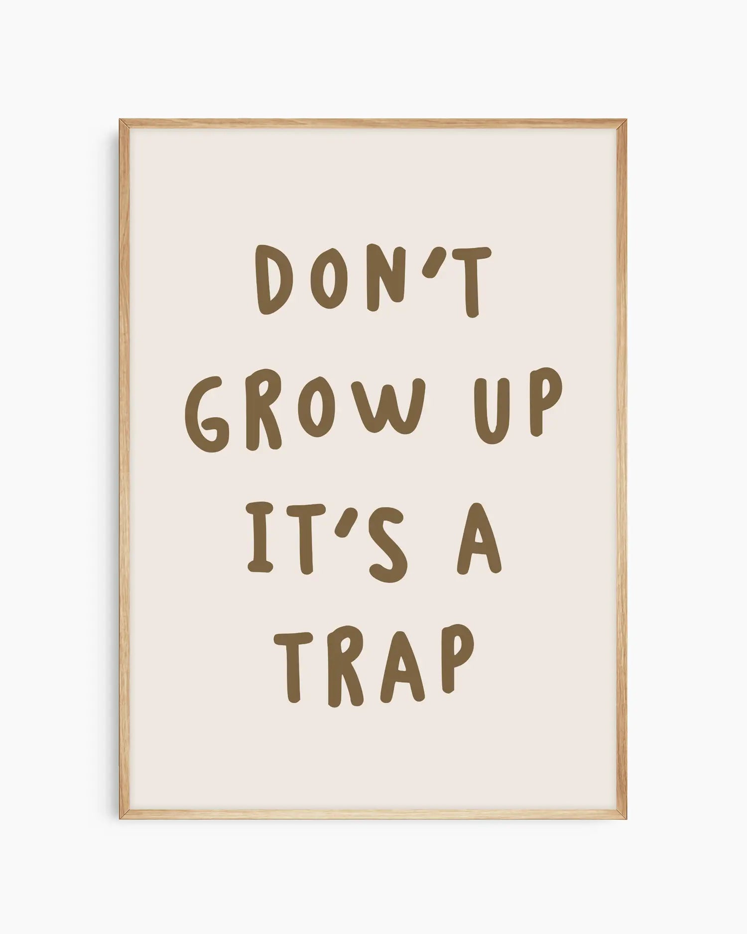 Barntavla med texten “DON’T GROW UP IT’S A TRAP” i brunt, inramad i ekram som ger ett naturligt och harmoniskt uttryck.