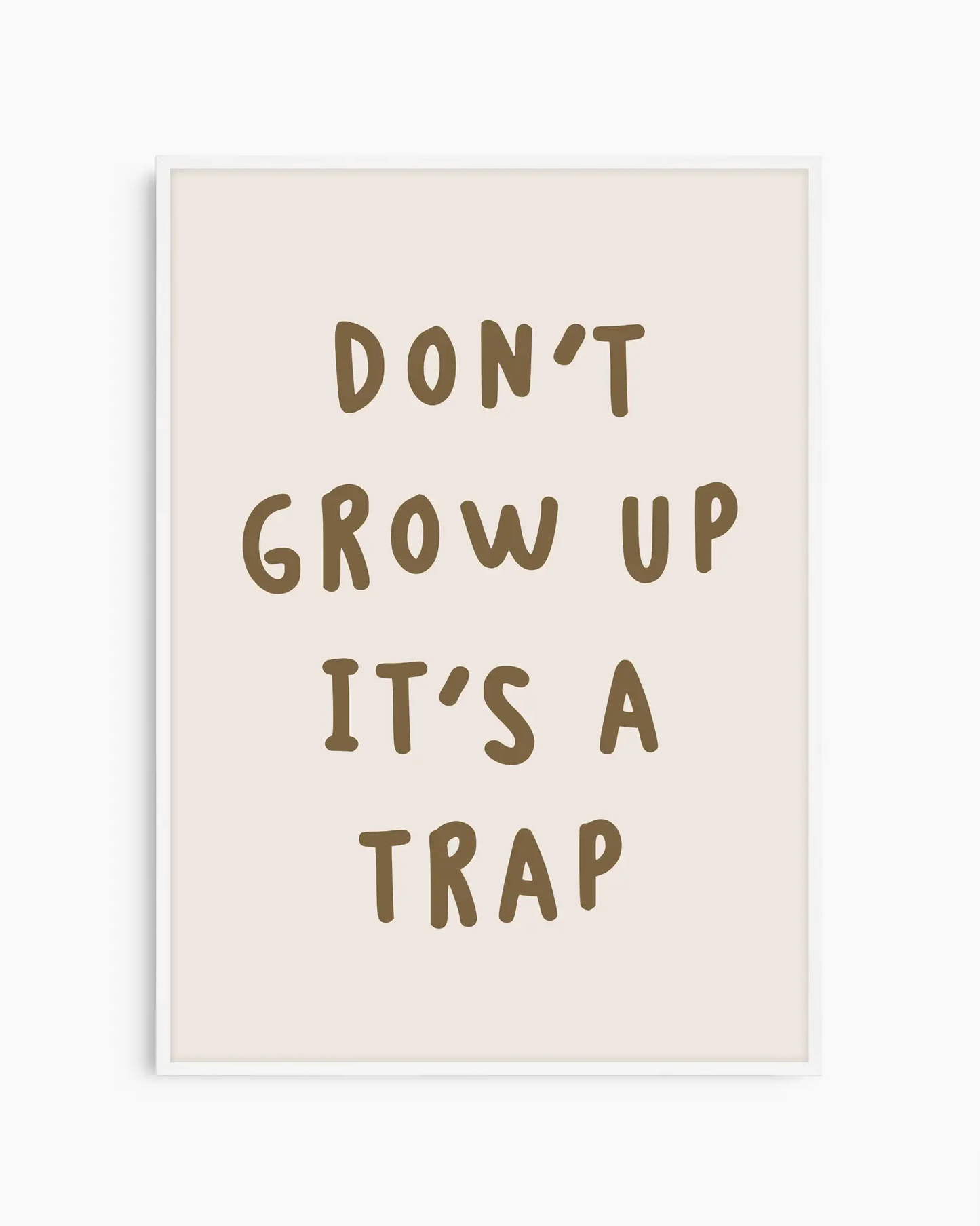 Barntavla med citatet “DON’T GROW UP IT’S A TRAP” på ljus beige bakgrund, inramad i vit träram för ett ljust och lekfullt intryck.