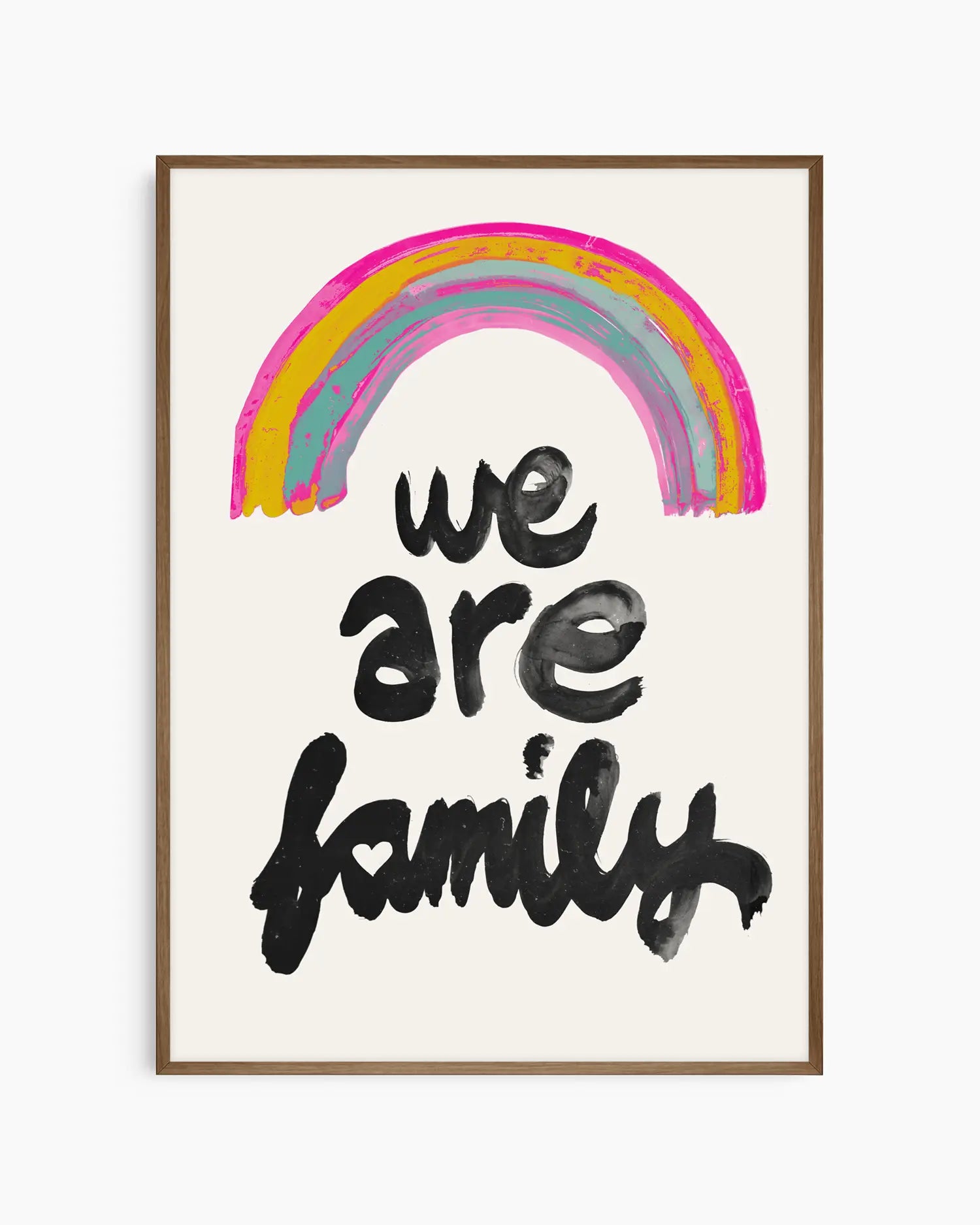 Barntavla med färgstark regnbåge och budskapet "WE ARE FAMILY", inramad i mörk ekram som skapar en mjuk kontrast mot den ljusa bakgrunden.