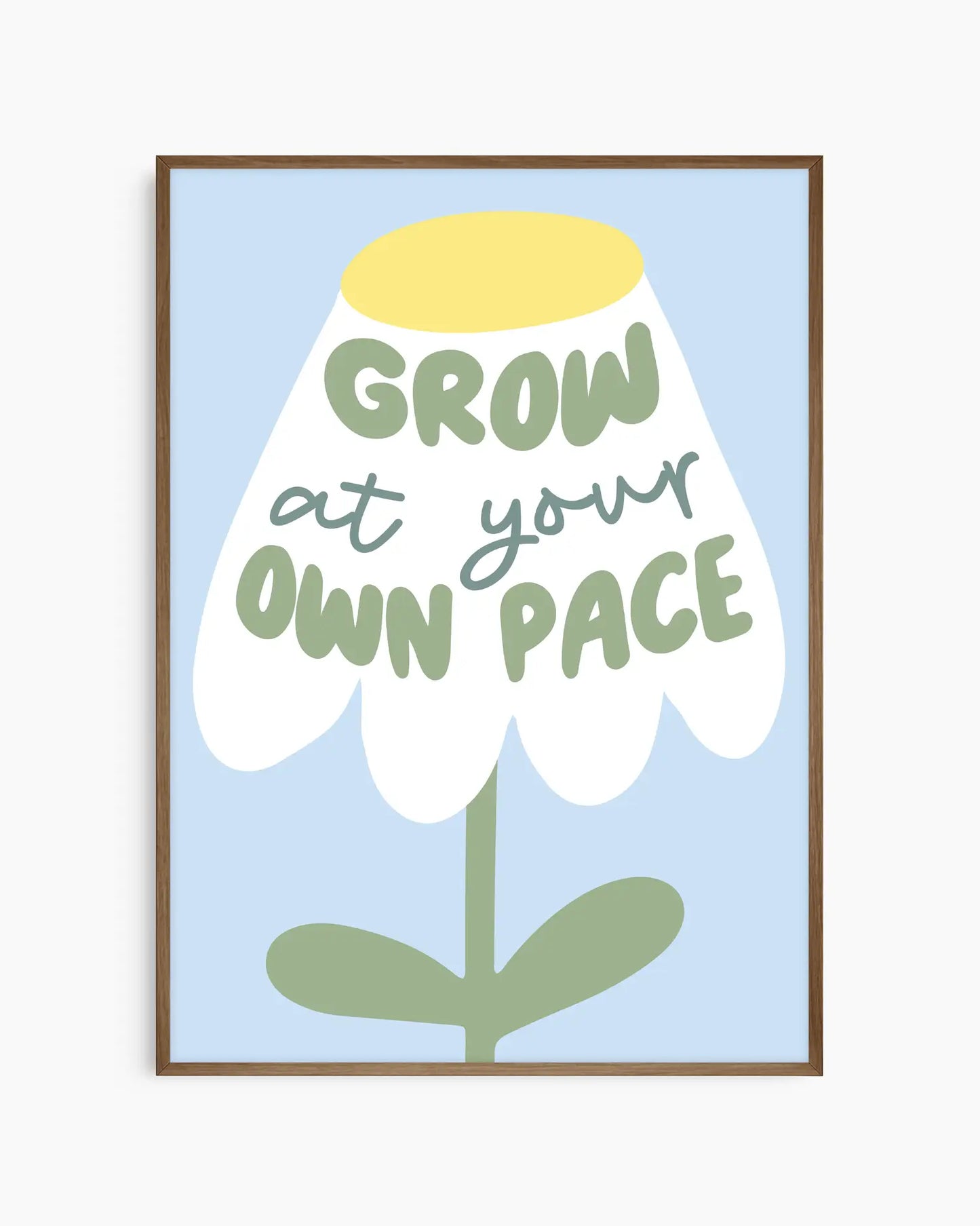Barntavla med stiliserad blomma och texten "GROW AT YOUR OWN PACE" på ljusblå bakgrund, inramad i mörk ekram. En harmonisk och inspirerande detalj för barnets rum.