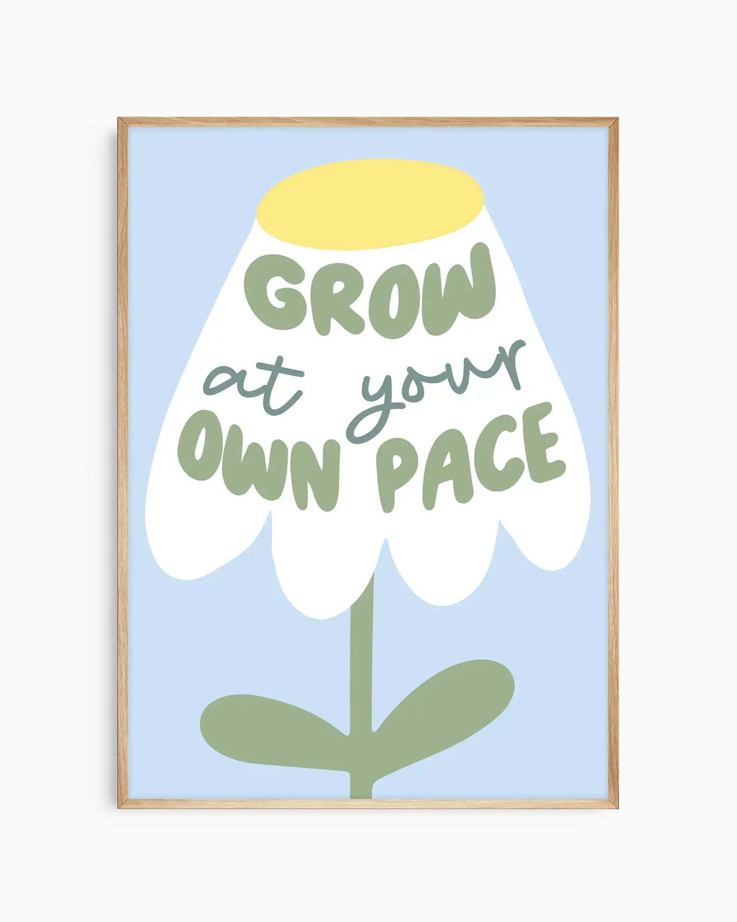 Barntavla med enkel blomillustration och texten "GROW AT YOUR OWN PACE" på ljusblå bakgrund, inramad i ekram. En lugn och positiv väggdekoration för barnrum.