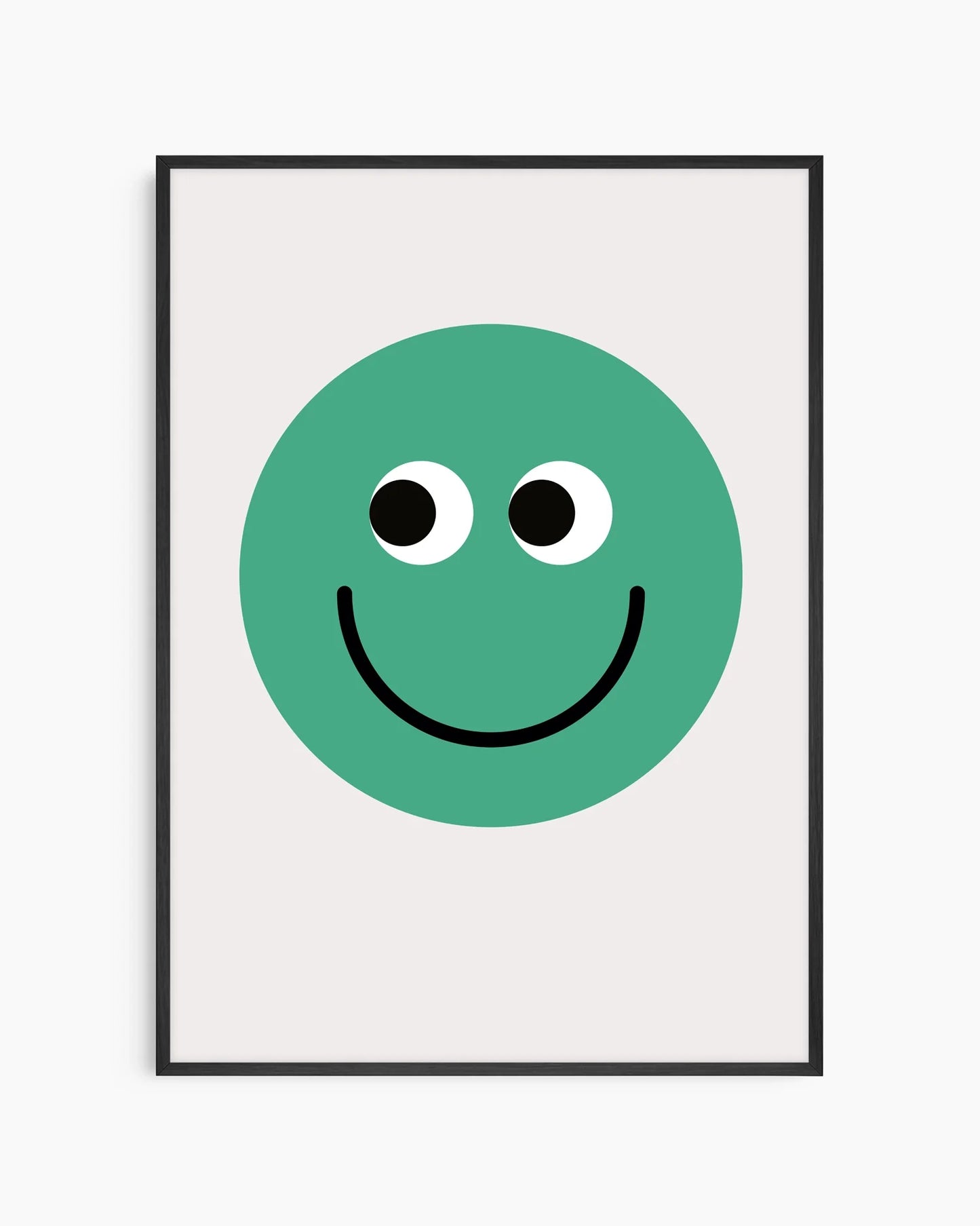 Barntavla med grön smiley på ljus bakgrund, inramad i svart träram som ger ett stilrent och modernt uttryck.
