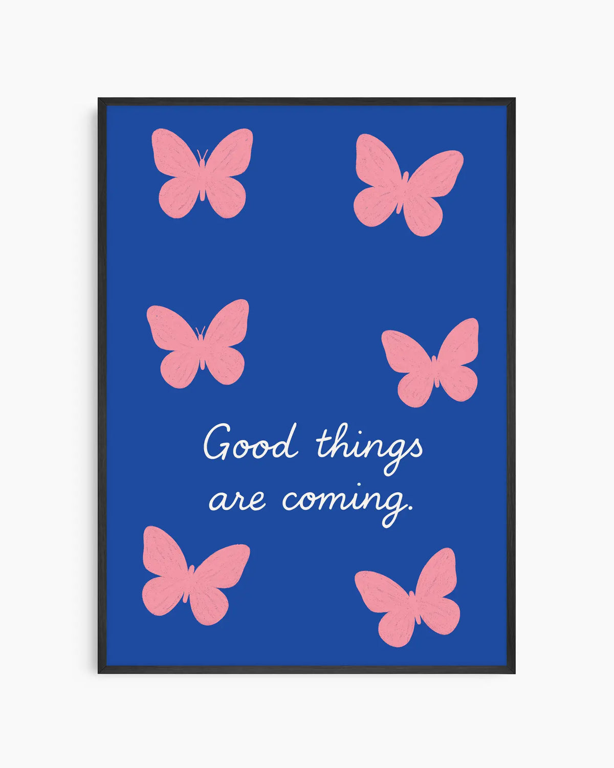 Barntavla med rosa fjärilar på djupblå bakgrund och texten "GOOD THINGS ARE COMING" i vit handskriven stil, inramad i svart träram.