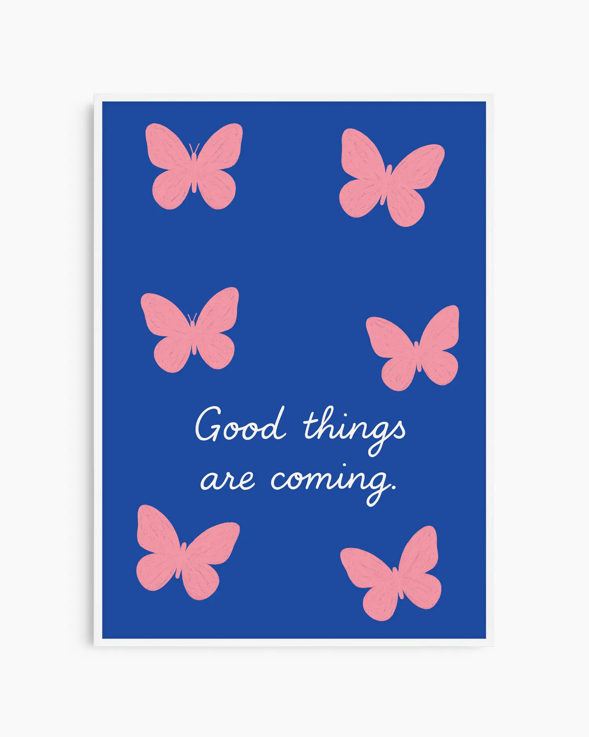 Barntavla med rosa fjärilar och mjuk typografi med texten "GOOD THINGS ARE COMING", inramad i vit träram för ett ljust uttryck.
