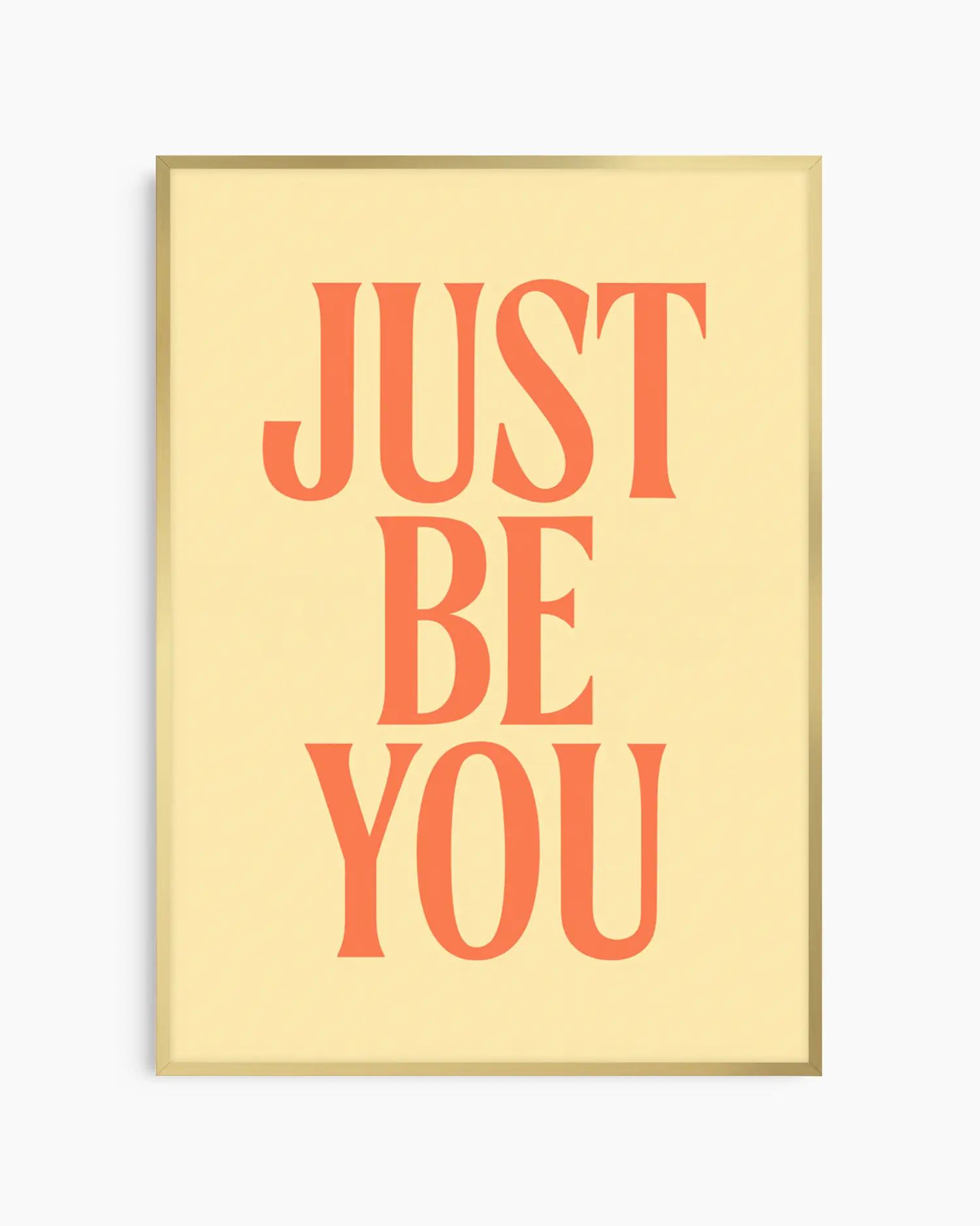 Barnrumstavla med texten "JUST BE YOU" i orange på ljus gul bakgrund, inramad i guld aluminiumram. En elegant och inspirerande väggdetalj.