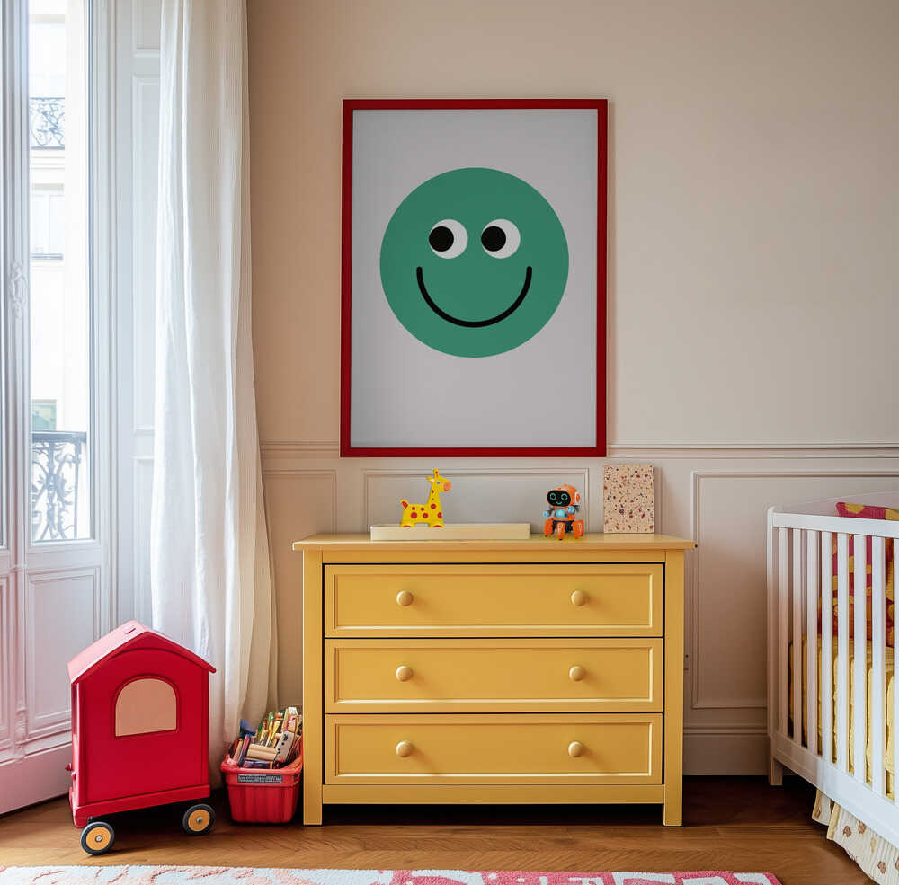 Inramad barntavla med grön smiley hängandes ovanför den gula byrån och tillför ett glatt och lekfullt uttryck till rummet.