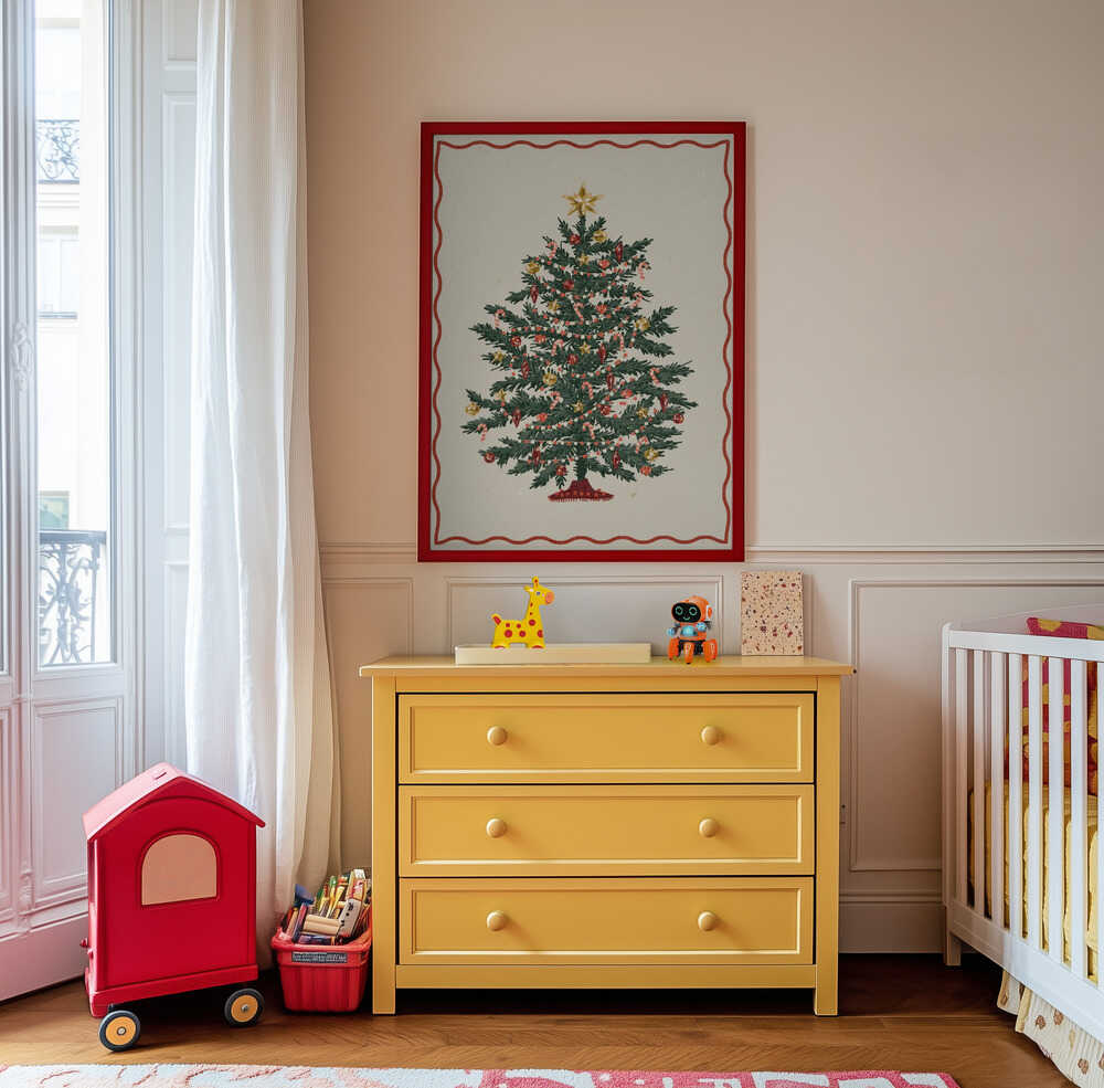 Inramad barntavla med en juligt pyntad gran, upphängd ovanför den gula byrån där den sprider varm och lekfull julstämning.