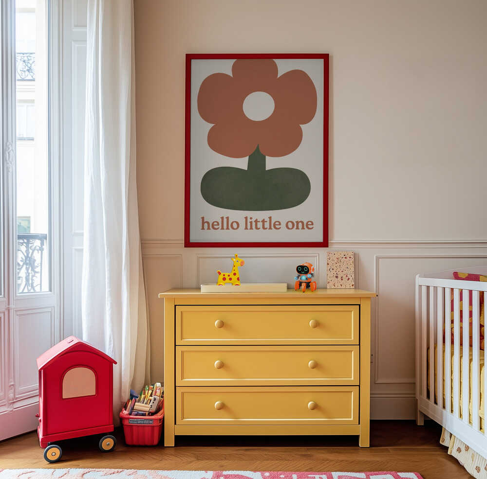 Inramad barntavla med blomman och texten "HELLO LITTLE ONE" placerad ovanför byrå i ett harmoniskt barnrum.