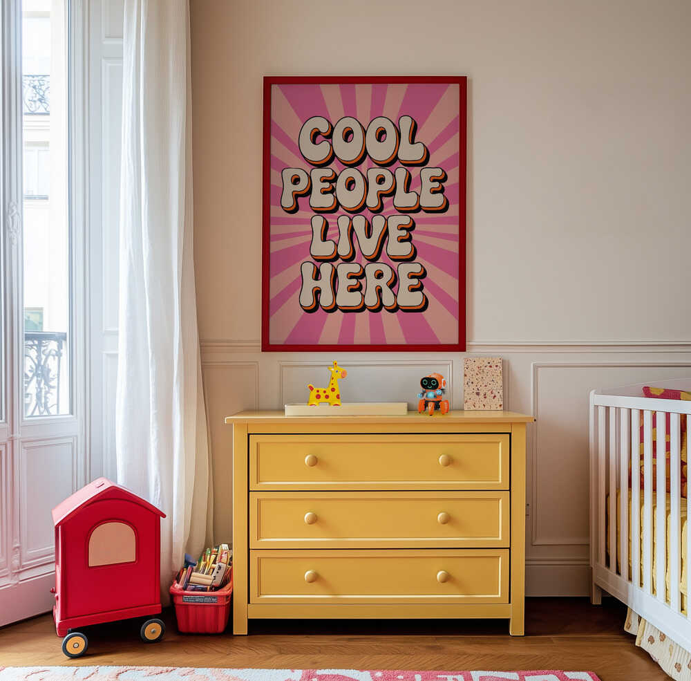 "Cool people live here" barntavla ovanför en gul byrå med leksaker i ett färgglatt barnrum. De starka färgerna i rosa och orange skapar ett roligt blickfång och ger rummet energi och personlighet.