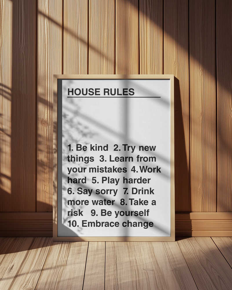 Barntavla med reglerna "HOUSE RULES" placerad på golvet mot träpanelvägg.