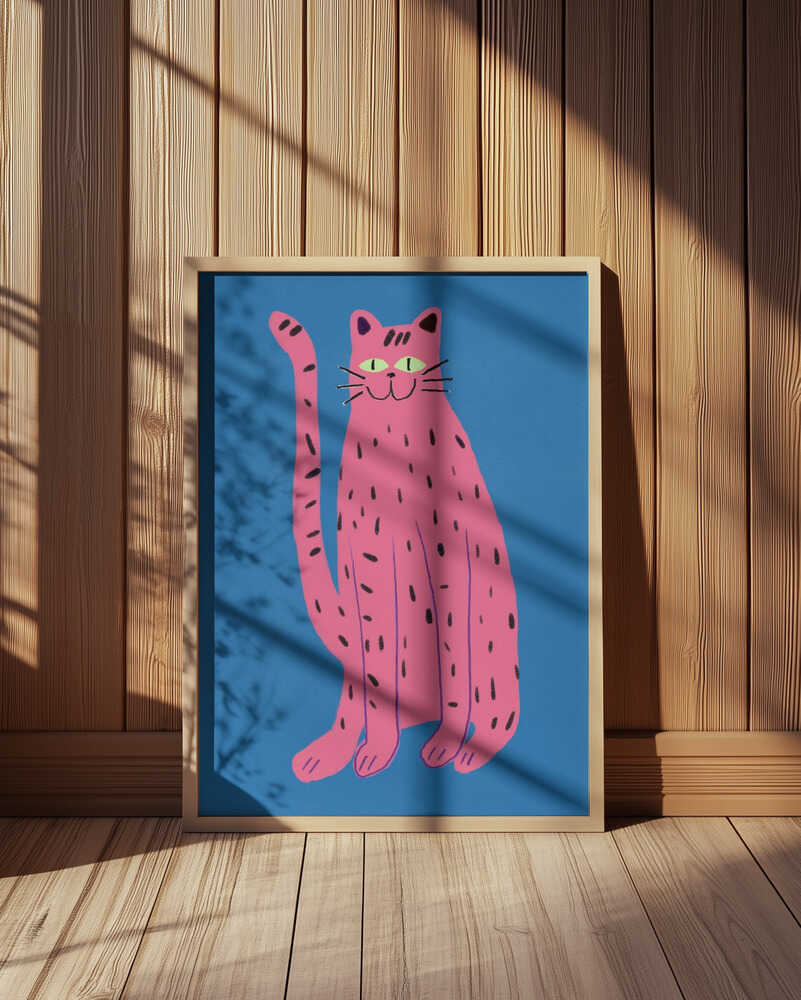 Inramad barntavla med rosa katt placerad mot träpanel där de starka färgerna kontrasterar fint mot naturmaterialet.