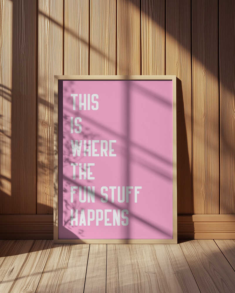Inramad barntavla med rosa textmotiv placerad mot träpanel där färgerna kontrasterar fint mot de naturliga tonerna.