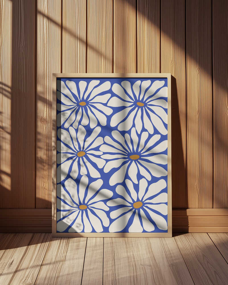 Inramad barnrumstavla med blommotiv i vitt och blått, placerad på golvet framför träpanel. En varm och modern inredningsdetalj.
