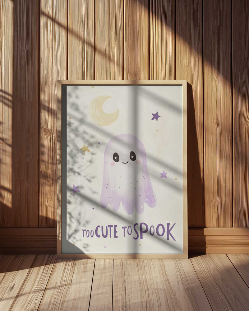 Inramad barntavla med lila spöke, stjärnor och måne och texten "Too Cute To Spook", placerad framför en träpanel som framhäver motivets mjuka färger.