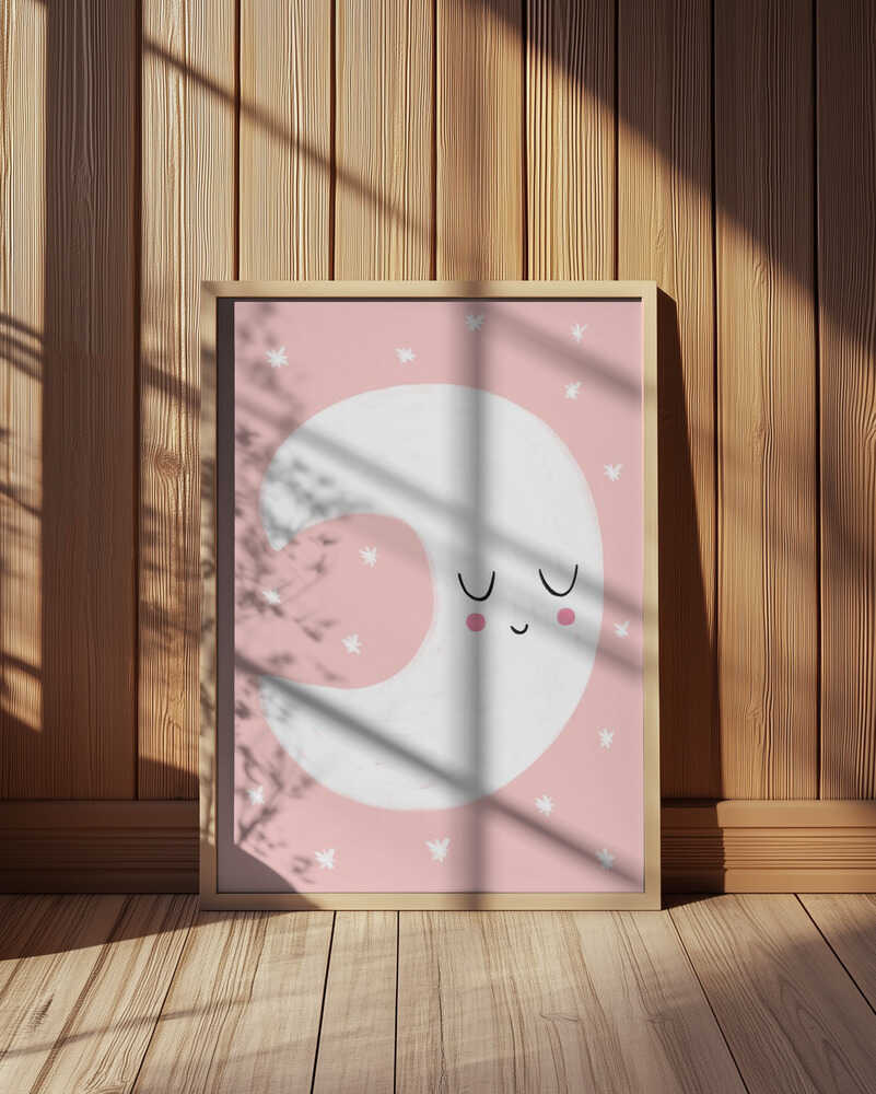 Inramad barntavla med en vit måne mot rosa bakgrund, placerad vid en träpanelvägg och tillför en varm, ombonad känsla.