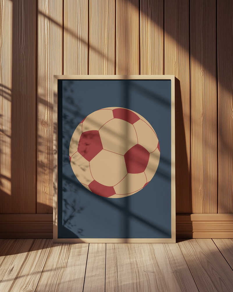 Inramad tavla med fotbollsillustration placerad mot en vägg med träpanel där färgerna framträder tydligt och levande.