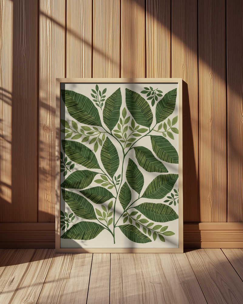 Inramad barntavla med gröna blad i olika former placerad på golvet framför en vägg med träpanel.