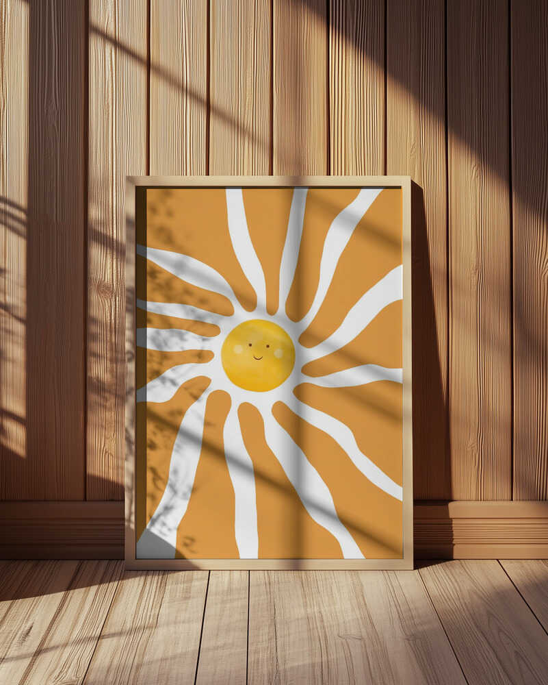 Inramad barntavla med sol placerad framför träpanel som framhäver illustrationens färger och form.