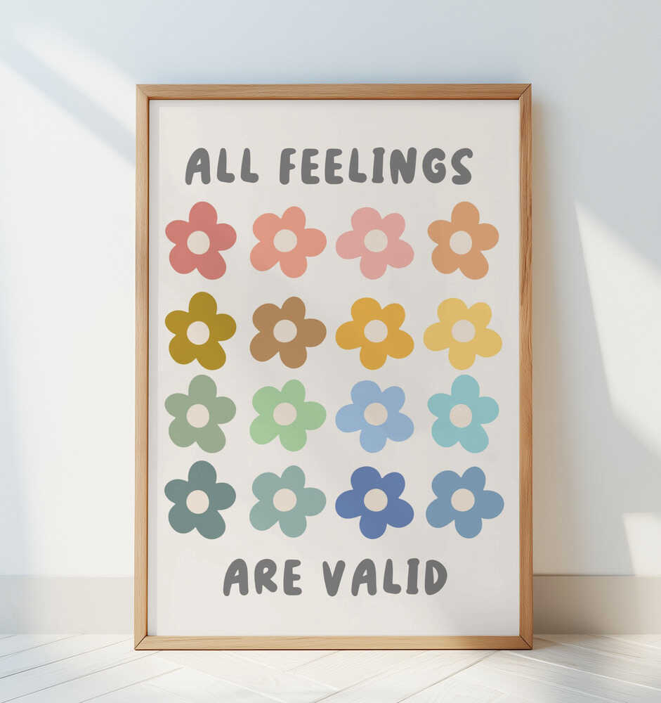 Inramad barntavla med blommotiv och texten "ALL FEELINGS ARE VALID" lutad mot en vit vägg. En stilren och lugn barnrumsmiljö.