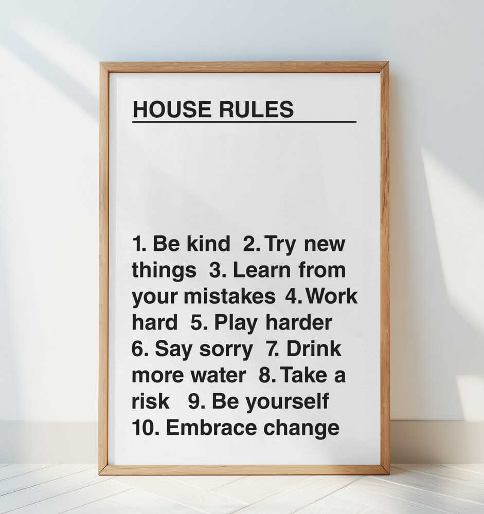 Barntavla med texten "HOUSE RULES" lutad mot en vit vägg i barnrumsmiljö.