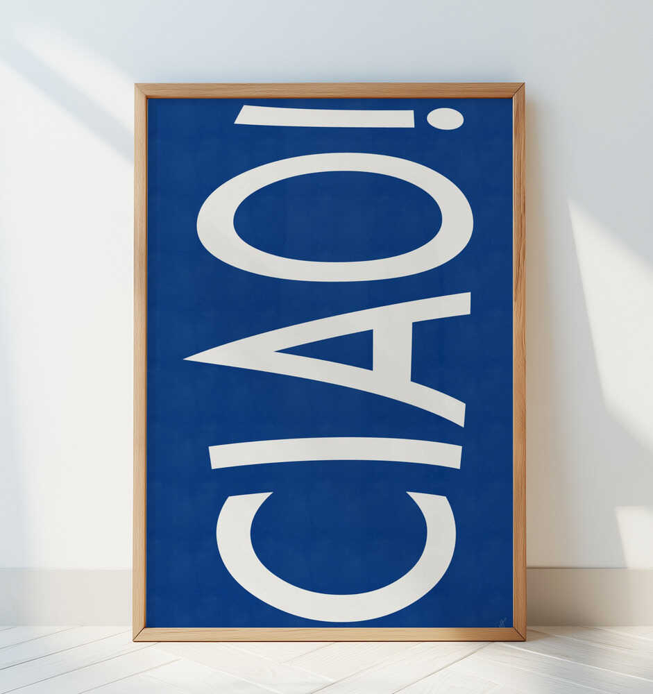 Barntavla med ”CIAO!” i vitt mot blå bakgrund lutad mot en vit vägg, vilket ger ett tydligt och grafiskt uttryck.
