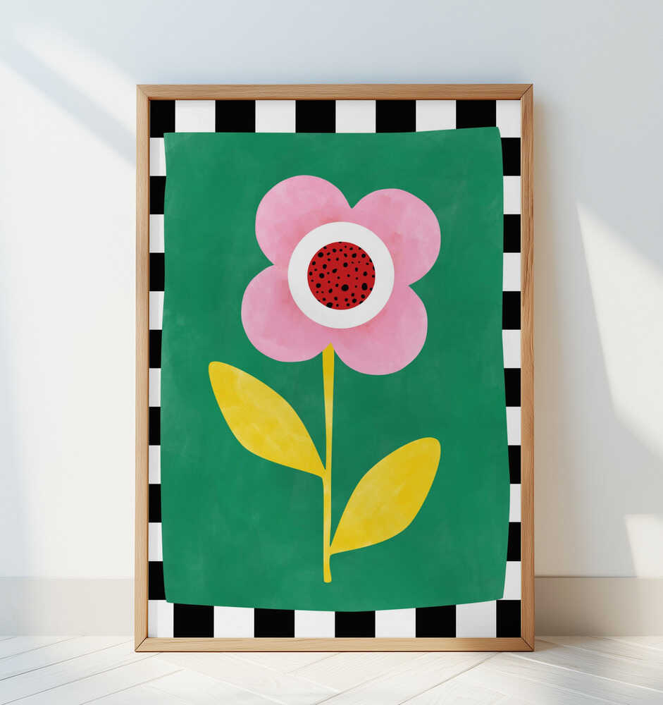 Inramad barnrumstavla med rosa blomma på grön bakgrund med svartvit ruta, lutad mot vit vägg. En pigg och modern färgaccent.