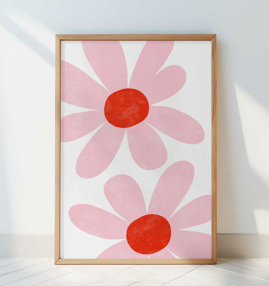 Inramad barntavla med två rosa blommor lutad mot en vit vägg och ger ett fräscht och lekfullt uttryck.