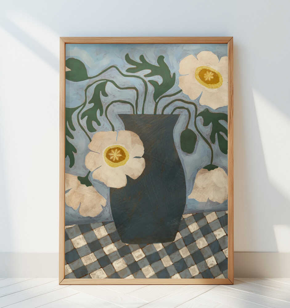 Inramad barntavla med blå vas och vita blommor lutad mot en vit vägg.