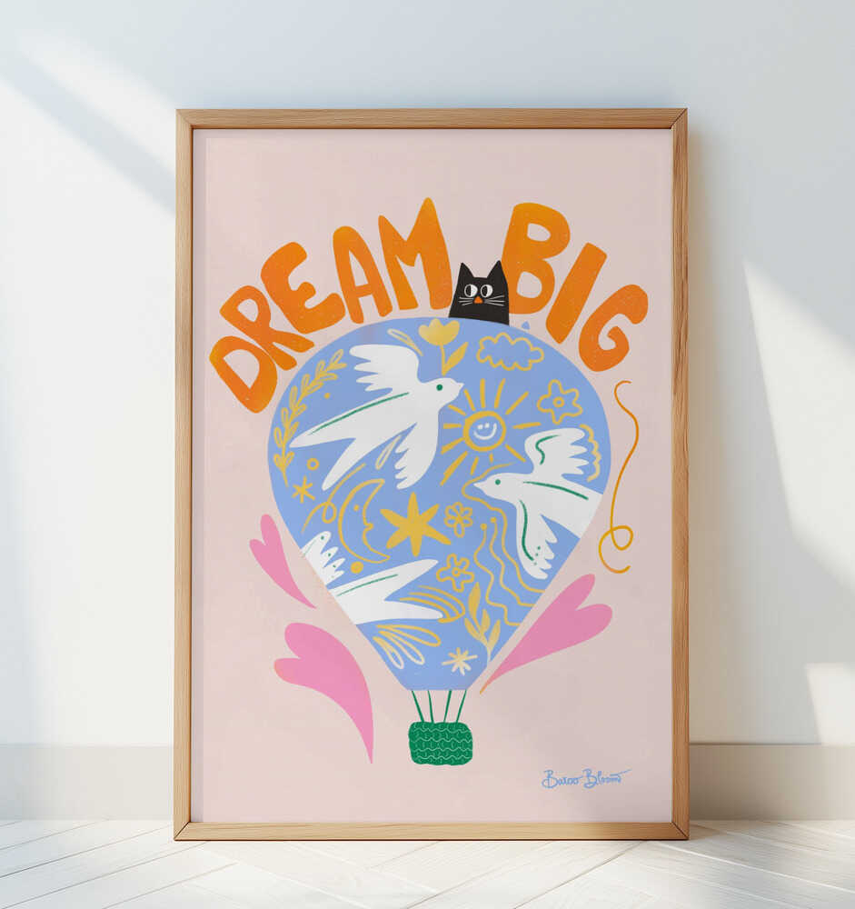 Barntavla med texten "DREAM BIG", lutad mot vit vägg i ett ljust rum. Luftballongens färger i blått, rosa och gult ger en lekfull kontrast i den ljusa miljön.