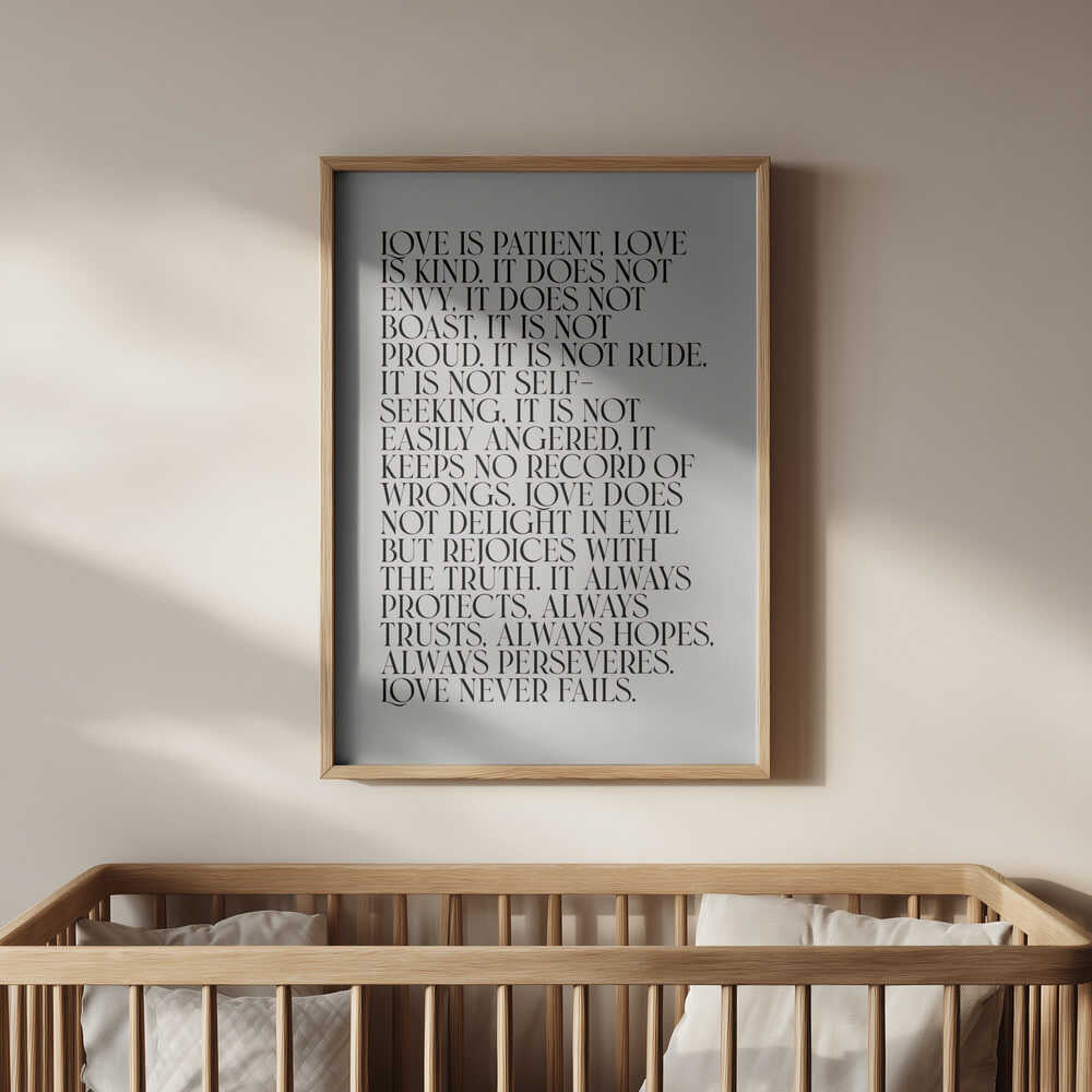 Barntavla med LOVE-citat i ram, placerad ovanför spjälsängen. En trygg och kärleksfull detalj i barnrummet.