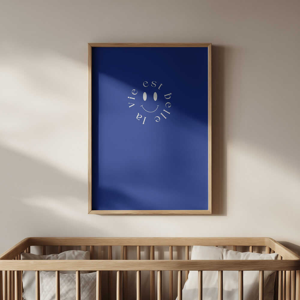 Barntavla med blå bakgrund och vit smiley placerad ovanför spjälsängen, vilket skapar en glad och inspirerande detalj i barnrummet.