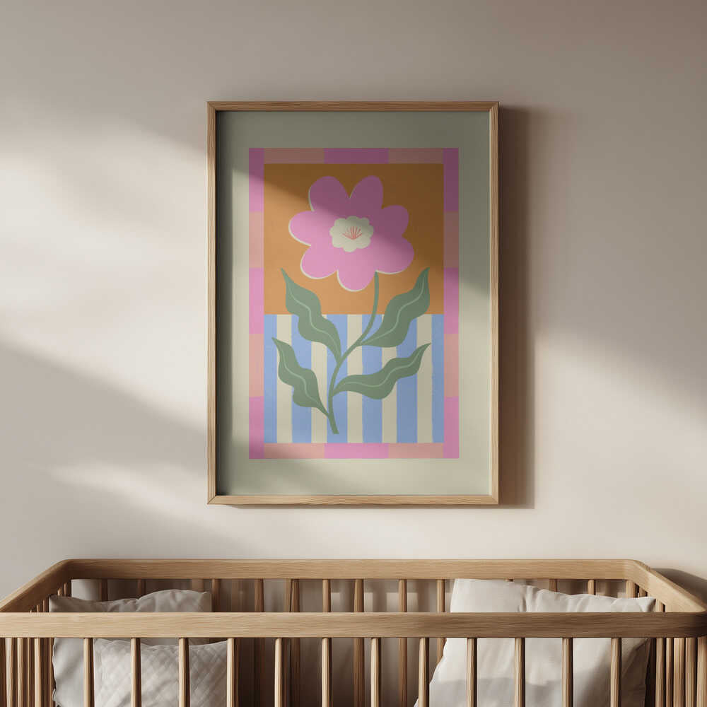 Inramad barnrumstavla med rosa blomma och färgrik bakgrund, placerad ovanför spjälsängen. En harmonisk och glad detalj för barnrummet.