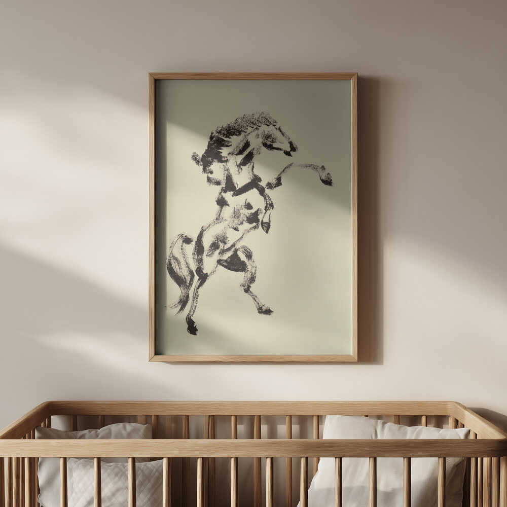 Inramad tavla med stegrande häst i svart toner placerad ovanför spjälsängen som ett mjukt men kraftfullt inslag i rummet.