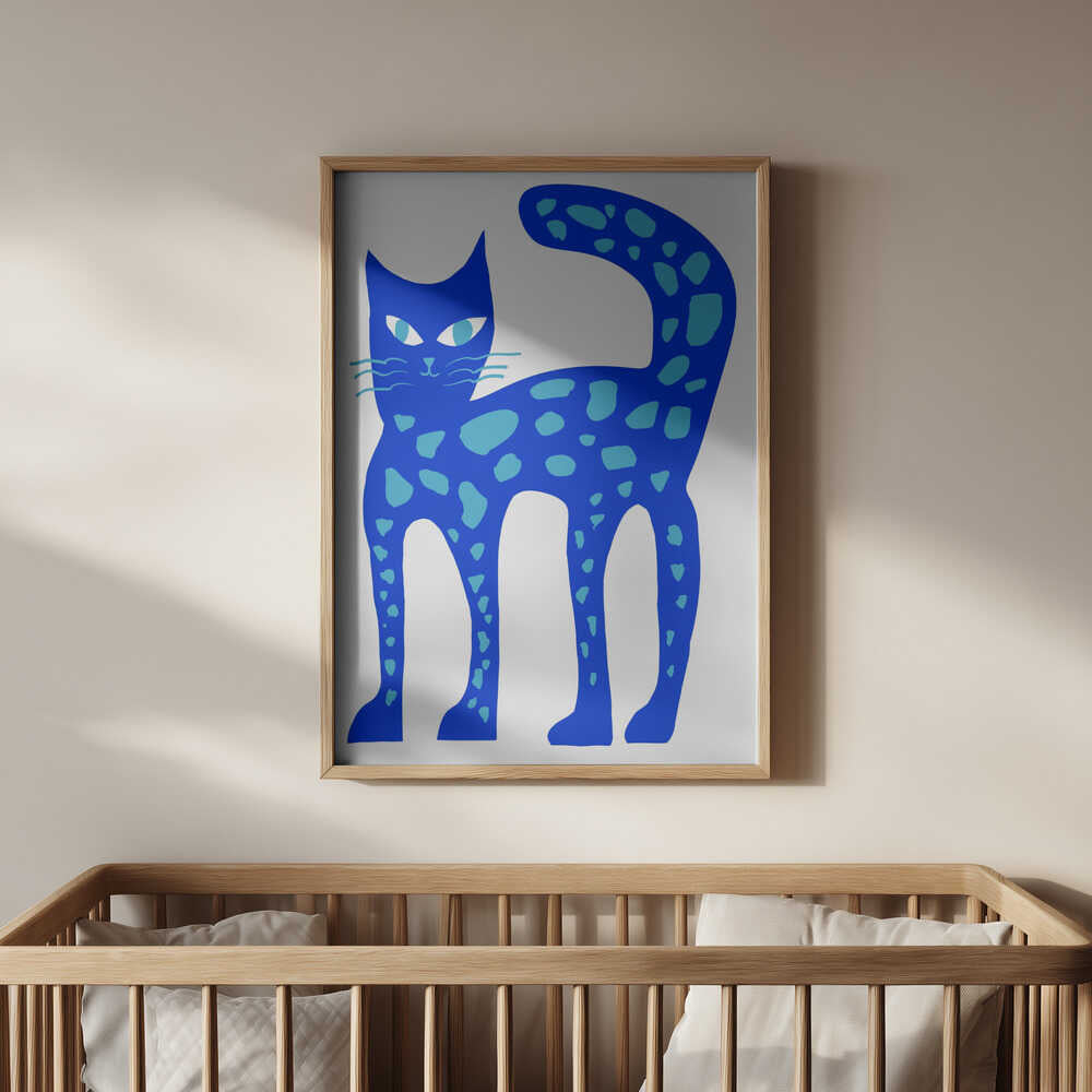 Inramad barntavla med blå katt ovanför spjälsängen som skapar en trygg och fantasifull känsla i barnrummet.