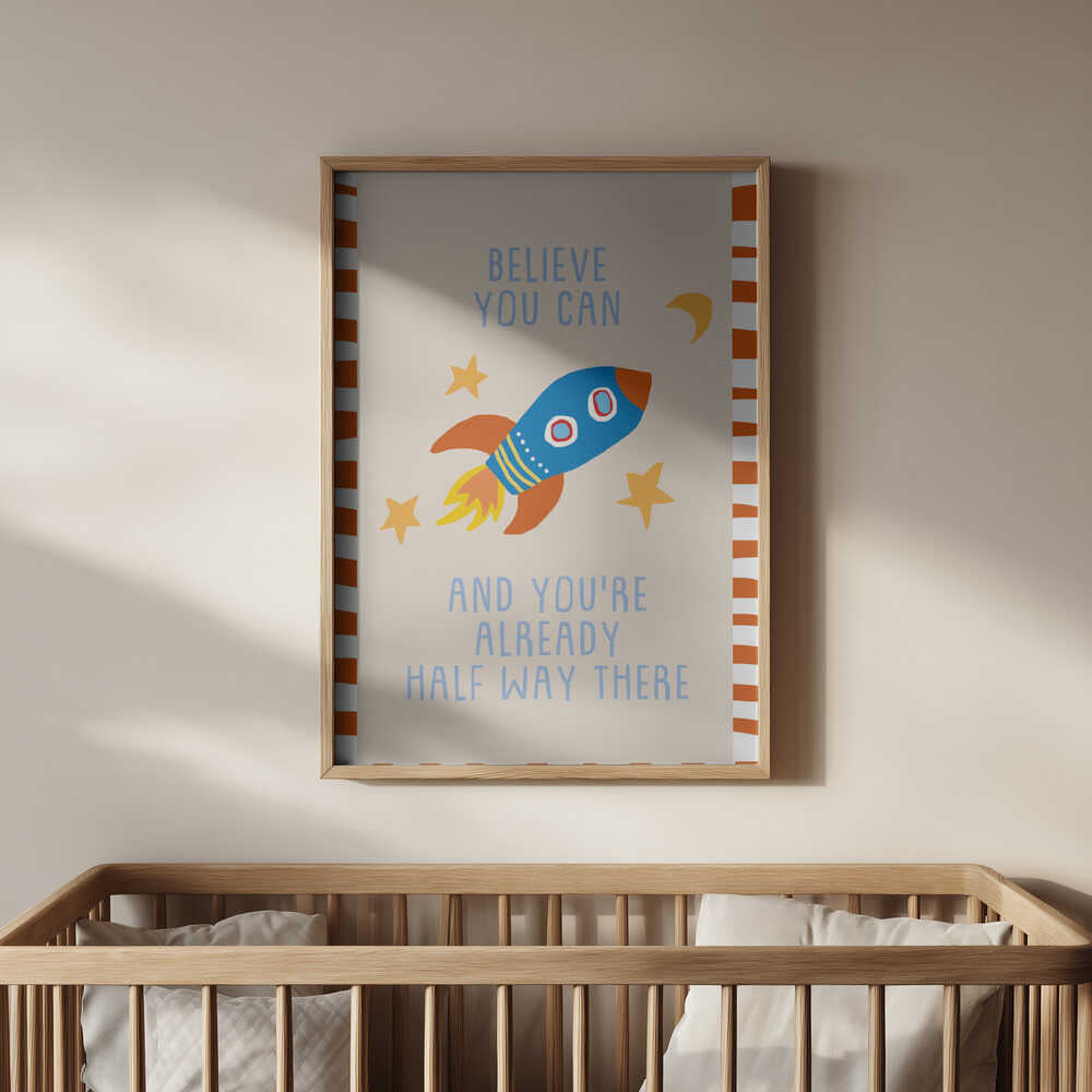 Inramad barntavla med raketmotiv ovanför spjälsängen, med tydligt fokus på den färgglada illustrationen och dess budskap.